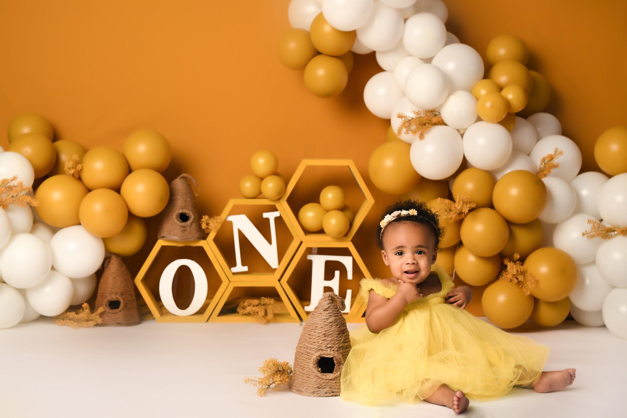 First birthday portrait in a cheerful bee-themed studio décor