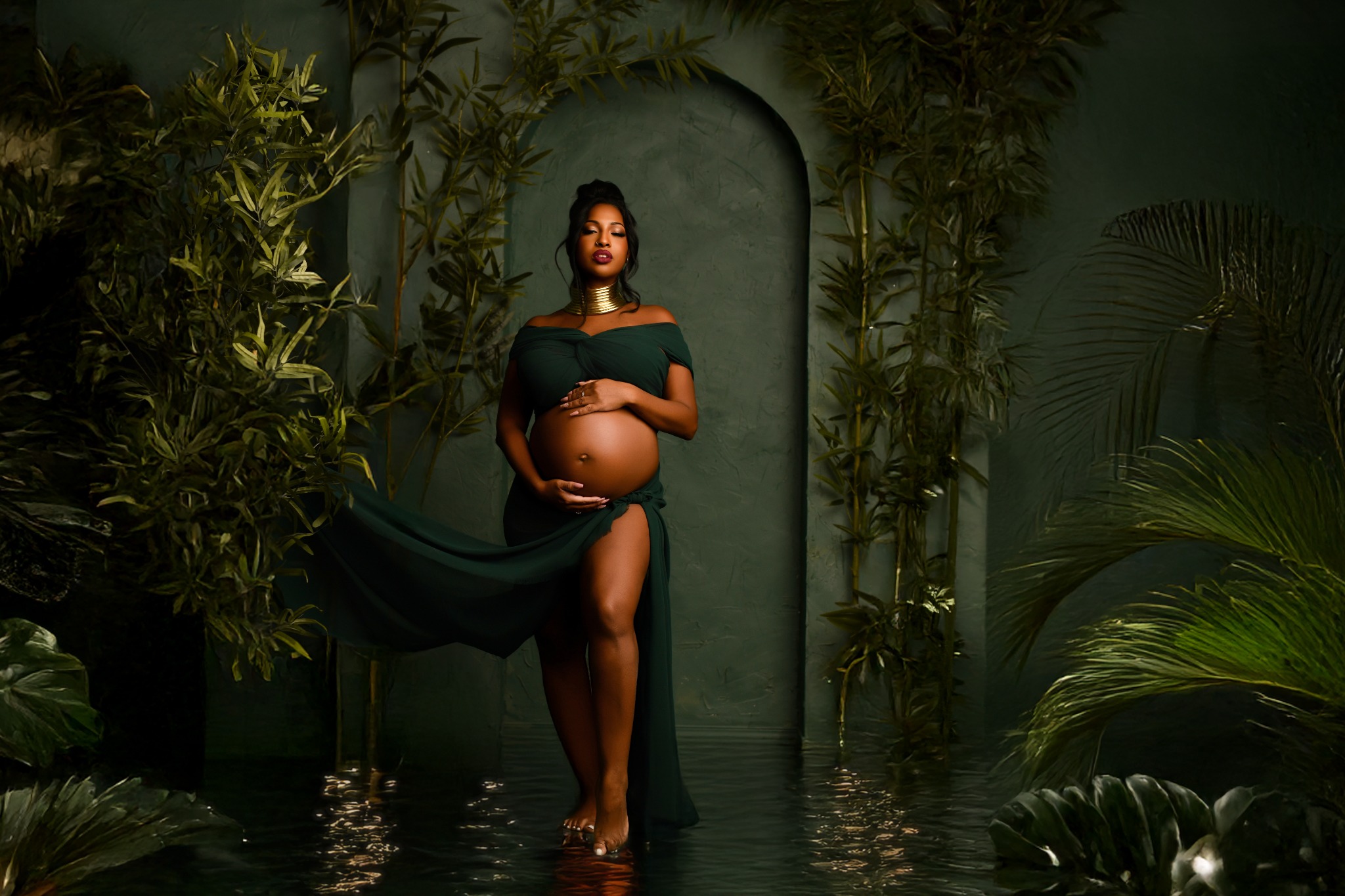 Elegant maternity portrait in a deep green botanical set by Natacha D Photographie