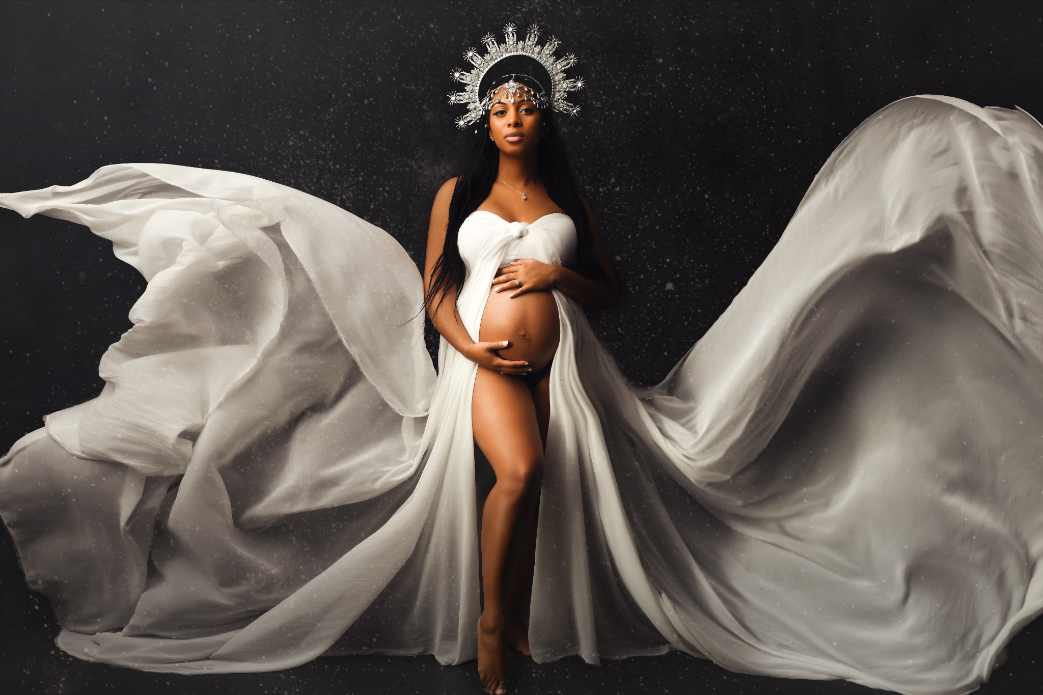 Pregnant woman wearing a white gown and crown in a Laval studio