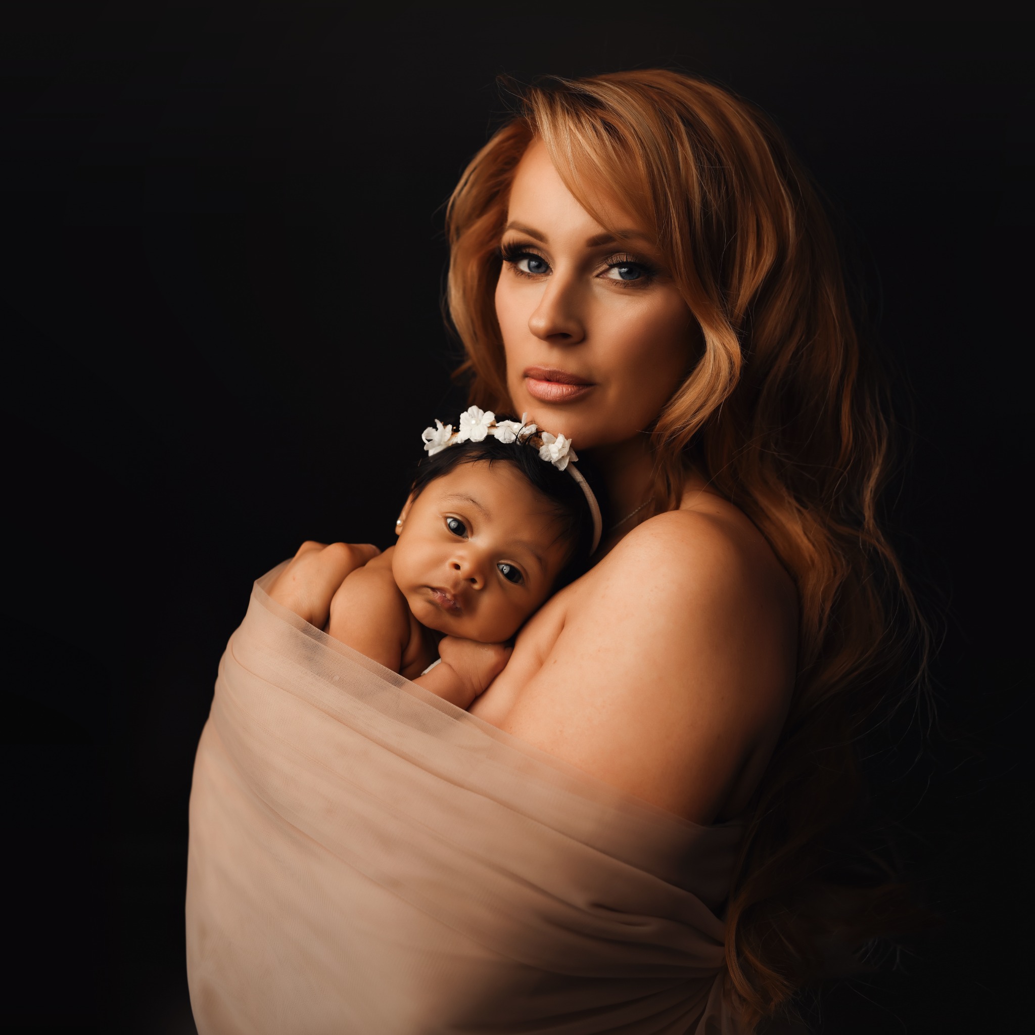 Mother holding her newborn baby in an intimate studio portrait